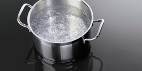 O cratiță cu apă clocotind pe o plită cu inducție AEG
