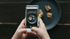 Un chef făcând o fotografie la o mâncare prezentată perfect